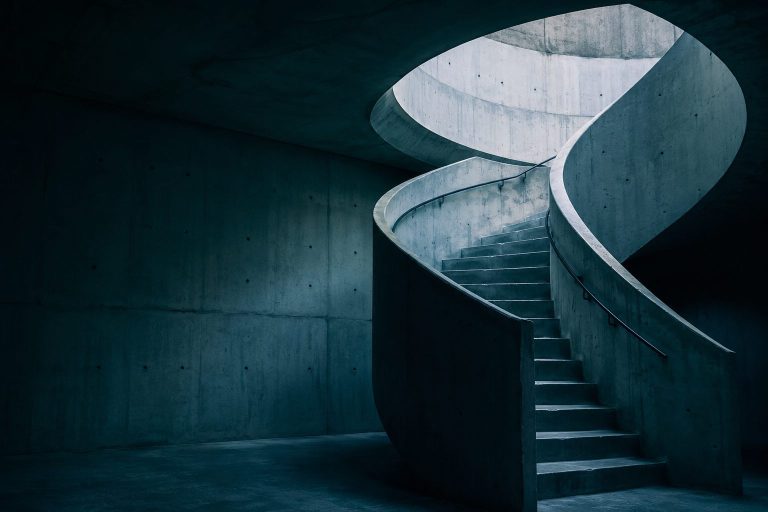 Escalera de caracol de hormigón iluminada desde arriba